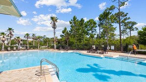 A swimming pool with clear blue water, surrounded by lounge chairs and palm trees. - 🌴Sea Esta | 4BR Coastal Retreat | Golf Cart + 6 Bikes | NatureWalk🌴 (Santa Rosa Beach)