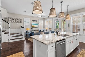 A spacious kitchen with a large island, white cabinetry, and a granite countertop. - 🌴Sea Esta | 4BR Coastal Retreat | Golf Cart + 6 Bikes | NatureWalk🌴 (Santa Rosa Beach)