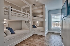 A room with bunk beds, a window with blinds, and a flat-screen TV mounted on the wall. - ☀️ Summer Sun | Steps from the Beach, Private Pool & Ocean Views 🌊 (Destin)