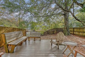 An outdoor wooden deck with benches and chairs, surrounded by trees and a wooden fence. - 2bed/1.5bath duplex; central Mount Pleasant, Near Beaches + Downtown! (Mount Pleasant)