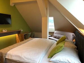 Un dormitorio con dos camas, un escritorio y un televisor.