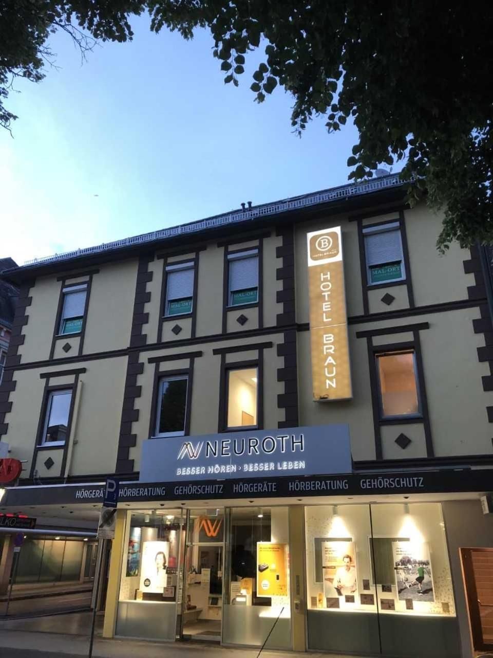 Un hotel llamado 'Hotel Braun' con un cartel que dice 'NeuRoTH' sobre la entrada.