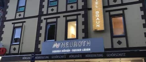 Un hotel llamado 'Hotel Braun' con un cartel que dice 'NeuRoTH' sobre la entrada.