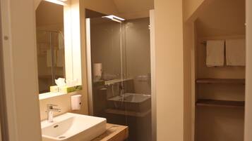 Ein Badezimmer mit Waschbecken, Spiegel und Dusche.