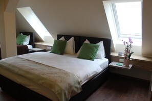 A bedroom with a large bed, two nightstands, a window, and a skylight. - Hotel Braun (Voitsberg)