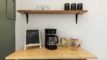 Ein Kaffeeangebot mit Kaffeemaschine, Tassen und Behältern für Kaffee, Zucker und Tee.