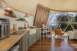 Eine moderne Küche mit einer Holz Arbeitsplatte, einem eingebauten Backofen und einem Essbereich mit Tisch und Stühlen.