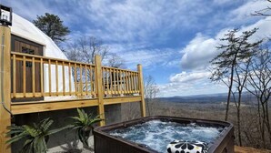 Un bain à remous avec une terrasse en bois et une vue sur le paysage.