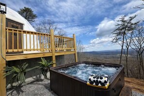 A hot tub with a wooden deck and a view of the landscape. - Charming 2-bedroom cabin with AC in peaceful Hays (Hays)