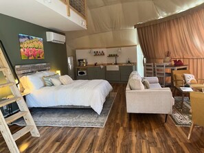 A bedroom with a bed, bedside table, and a painting on the wall. - Charming 2-bedroom cabin with AC in peaceful Hays (Hays)