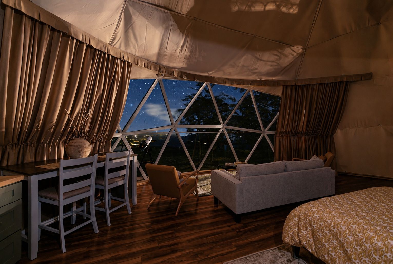 Een tent waarin een eethoek, een bank en een bed staan.