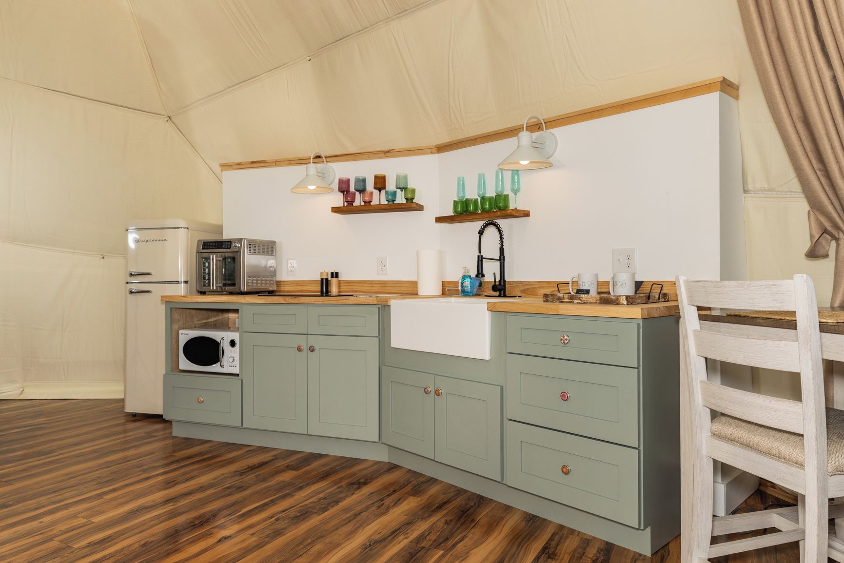 Een kleine keuken met een magnetron, broodrooster en spoelbak.