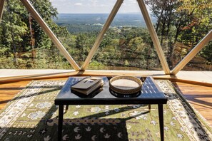 A view from a glass-roofed room with a table, a notebook, and a tambourine.