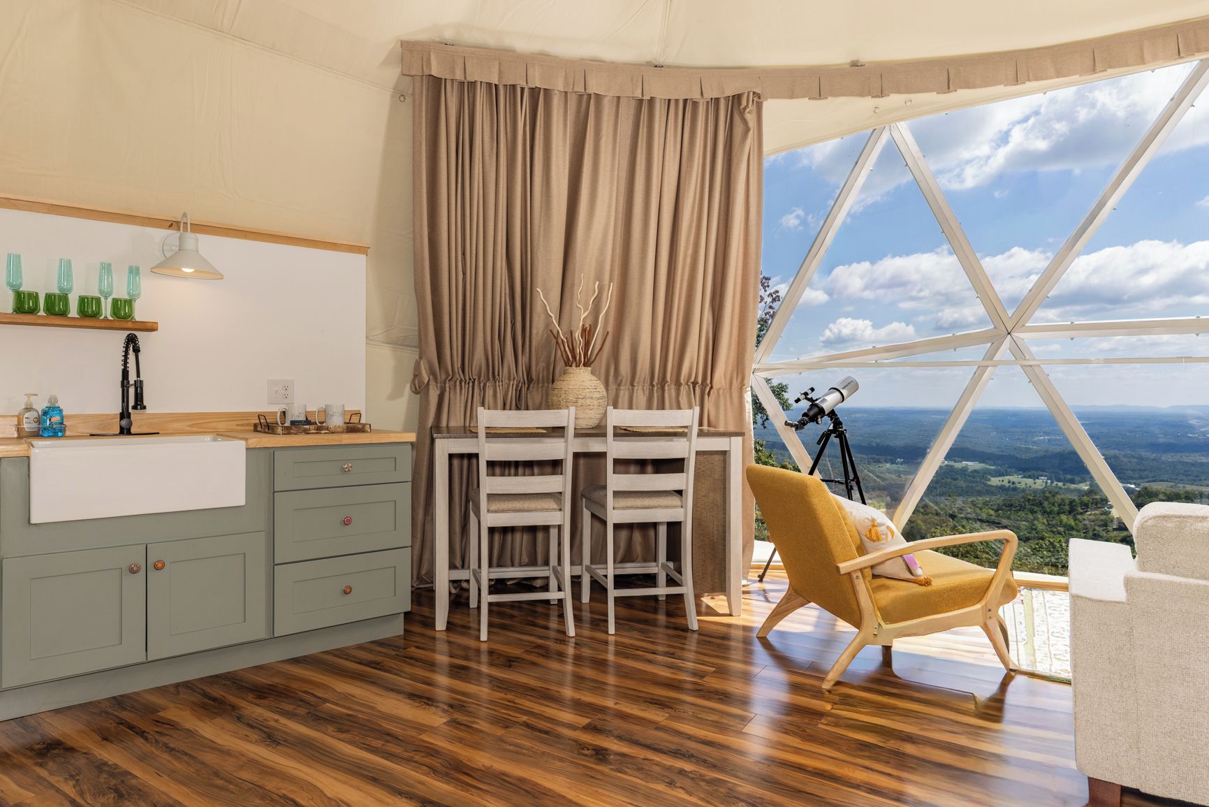 Ein Zimmer mit Essbereich, einem Teleskop und Blick auf die Landschaft.