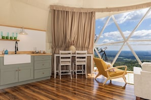 Una habitación con comedor, un telescopio y vistas al paisaje.