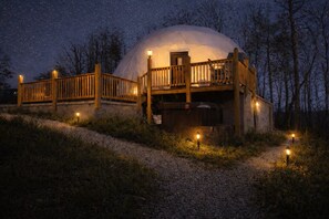 A dome-shaped structure with a wooden deck and railing, surrounded by a gravel path and trees. - Charming 2-bedroom cabin with AC in peaceful Hays (Hays)