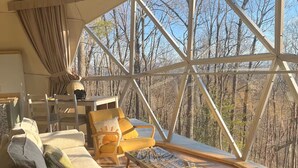 A cozy interior with a large window, a sofa, chairs, and a table. - Charming 2-bedroom cabin with AC in peaceful Hays (Hays)