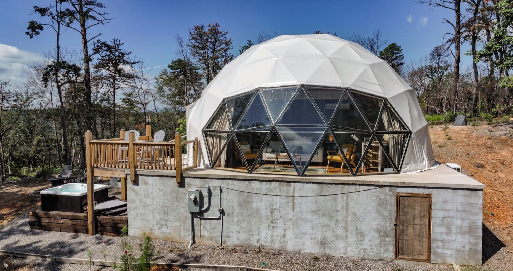 A geodesic dome structure with a deck and outdoor seating area.