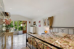 A bedroom with a bed, bedside table, dresser, window with curtains, and a view of greenery outside. - Holiday Home 'Annette' with Mountain View, Wi-Fi and Air Conditioning (Bargemon)