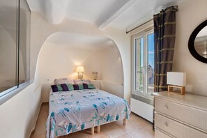 A bedroom with a bed, two bedside lamps, a dresser, a window with curtains, and a mirror on the wall. - Holiday Home 'Au Bon Accueil' with Mountain View, Private Terrace and Wi-Fi (Fayence)
