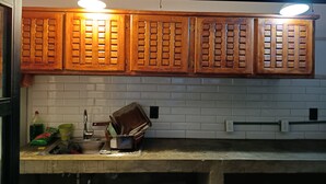 A kitchen with wooden cabinets, a sink, and various kitchen items. - House Santy Co-Living Condesa (Ciudad de México)