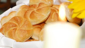Una cesta blanca llena de panecillos dorados.