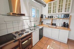 A modern kitchen with a gas stove, double sink, and a coffee machine. - Family-friendly chalet with a magnificent view and a terrace (Euseigne)