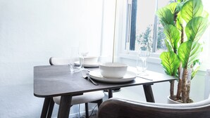 Uma mesa de jantar com uma planta em vaso, uma tigela e um copo.