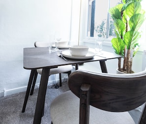 A dining table with a potted plant, a bowl, and a glass. - The Stanley Arms Hotel by Guestz (Seascale)