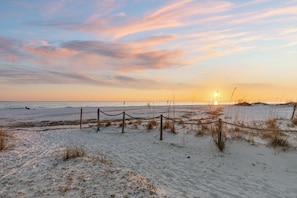 A beach with a rope barrier, sandy dunes, and the ocean.
