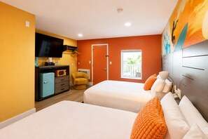 Ett hotellrum med två sängar, en TV, en minibar och ett fönster med utsikt.