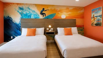 A hotel room with two beds, a mural of a surfer, and a poster on the wall.