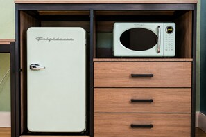 Una cocina con un refrigerador Frigidaire y un microondas sobre un mueble de madera.