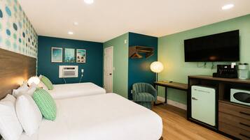 Una habitación de hotel con cama, escritorio, silla, televisión y cafetera.