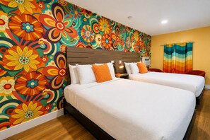 A hotel room with two beds, a colorful floral wall mural, a wooden headboard, and a striped curtain. - Pet-Friendly with Gulf Views - Steps to St. Joe Beach – Flower Power (Port St Joe)