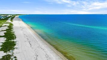 Una playa con vista clara al océano y una costa arenosa.