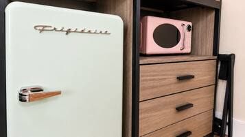 Un refrigerador de estilo vintage con un cajonero debajo.