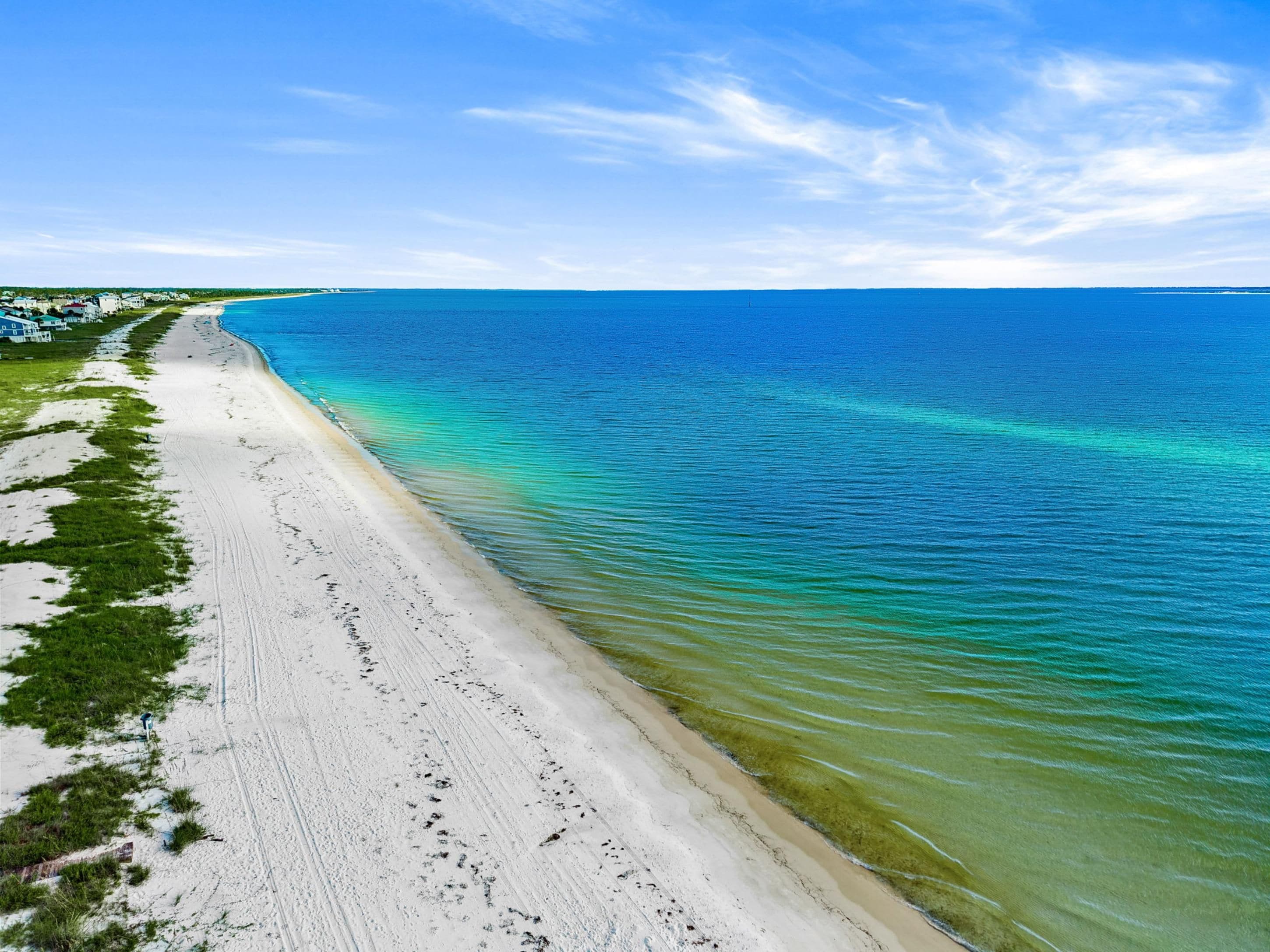 A beach with a clear view of the ocean and a sandy shoreline.