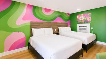 A room with two beds, a green wall, and a colorful abstract mural.