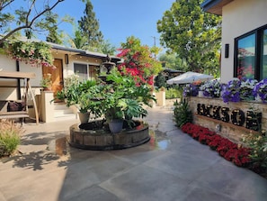 A courtyard with a circular planter, potted plants, and a stone wall with the name 'JACKSON'. - Private Rooftop Loft at Jackson Market (Culver City)