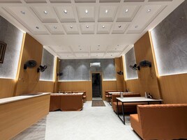 A modern interior with a reception desk, seating areas, and a staircase leading to an upper level.