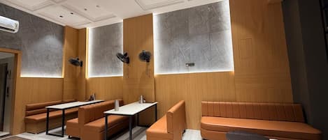 Interior moderno com disposição de assentos, teto com iluminação embutida e unidade de ar condicionado na parede.