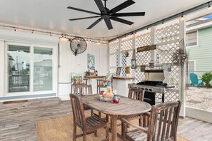 An outdoor patio with a wooden table and chairs, a ceiling fan, string lights, and a grill. - Hook, Wine and Sinker ~3 Bed / 2 Bath Home with a Pool! (Rockport)