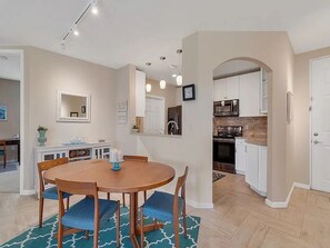 Une cuisine moderne avec des meubles blancs, un four encastré et un four à micro-ondes.