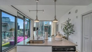 Una cucina moderna con un'ampia finestra, elettrodomestici in acciaio inossidabile e luci a sospensione.