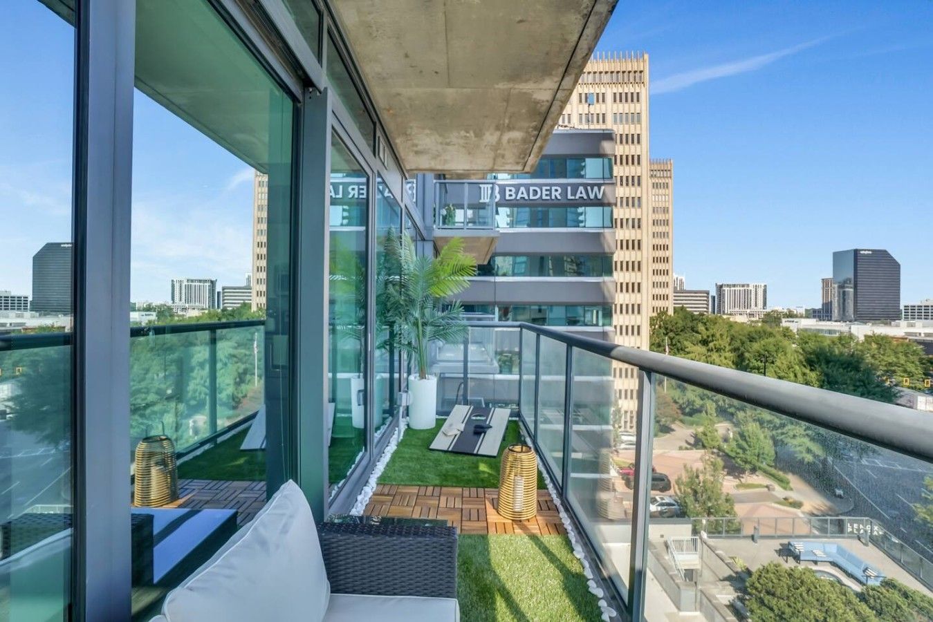 A modern building with a glass facade, a view of a cityscape, and a sign for 'BADER LAW' on the building.