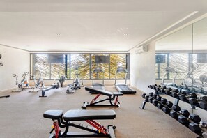 Ein Fitnessstudio mit Laufbändern, Kraftbänken und Kurzhanteln.