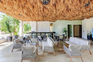 An outdoor seating area with wicker furniture, a bar, and a thatched ceiling. - 2 bedrooms Penthouse w/ Private jungle terrace (Tulum)