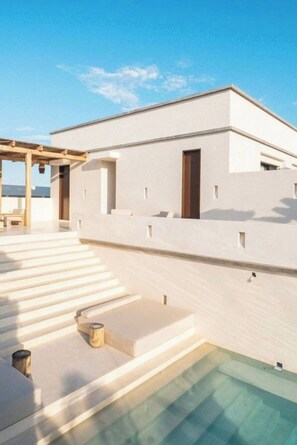 A modern building with a pool, a covered outdoor area, and a clear sky. - La Veleta · Exclusive private pool · 1BR couple (Tulum)
