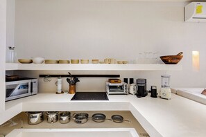 Eine moderne Küche mit Mikrowelle, Toaster, Kaffeemaschine und Mixer auf der Arbeitsfläche.